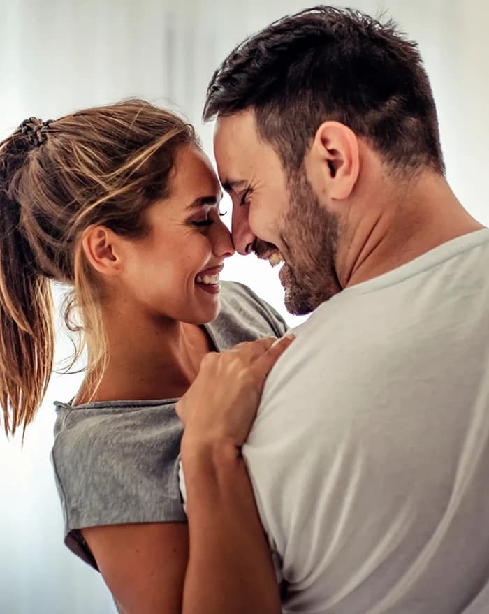 A couple laughing together in a warm everyday moment